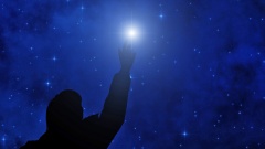 Ein Mensch zeigt auf einen leuchtenden Stern am Abendhimmel
