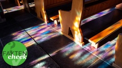 Kirchenbänke in buntes Licht gehüllt