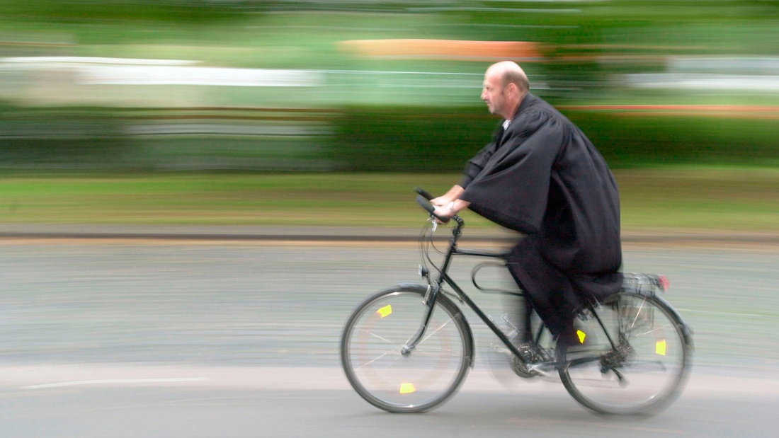 Pfarrer auf dem Fahrrad unterwegs