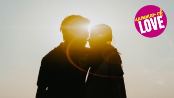 Ein Mann und eine Frau küssen sich vorm Sonnenuntergang