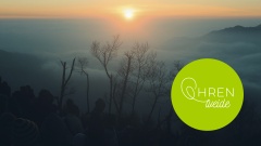 Menschen versammeln sich auf einem Berg bei Sonnenuntergang