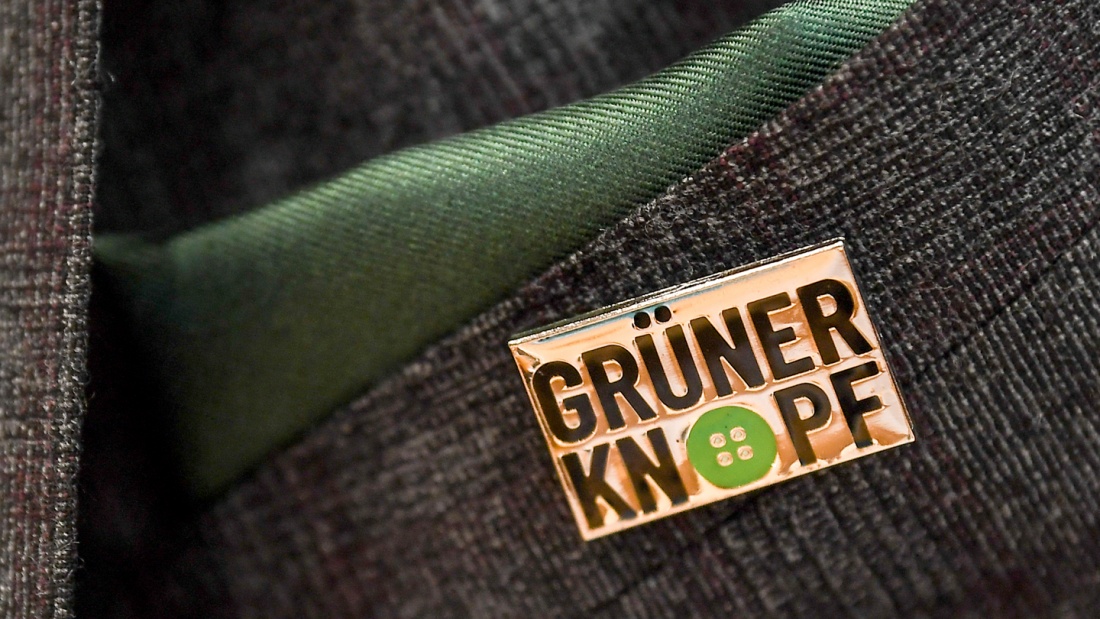 Anstecker mit dem Symbol des staatlichen Textilsiegel "Grüner Knopf".