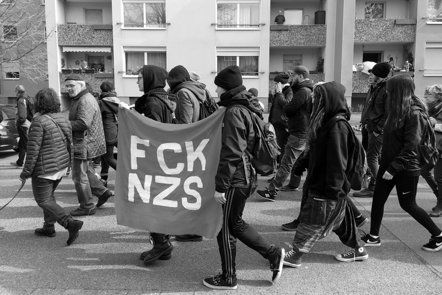 Demonstranten mit "FCKNZS"-Transparent.