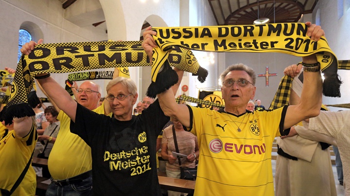 BVB-Fans schwenken BVB-Schals bei einem ökumenischen Gottesdienst in der Dreifaltigkeitskirche in Dortmund zu Beginn der neuen Saison von Borussia Dortmund. 