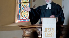 Pfarrer predigt auf der Kanzel.