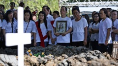 Indonesien, Surabaya: Familienmitglieder beten am Grab eines der Opfer der drei Terroranschläge auf christliche Kirchen am 13.05.2018. Die indonesische Polizei hat am 15.05.2018 im Zusammenhang mit den Selbstmordanschlägen einen Militanten erschossen und 1