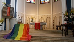 Foto zeigt Altar der Zwölf-Apostel-Kirche in Berlin. Auf den Stufen davor ist die Regenbogenfahne drapiert. Foto vom Gottesdienst zur Eröffnung des Lesbisch-schwulen Stadtfestes 2015.