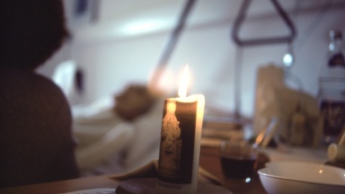 Kerze am Sterbebett eines Bewohners im Hospiz