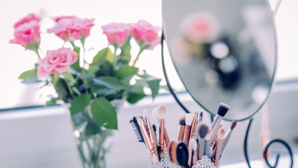 Spiegel, Blumen und Makeup-Pinsel