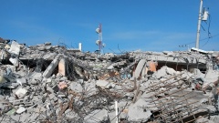 Aufgehäufte Trümmer und Schutt unter blauem Himmel in Pedernales.