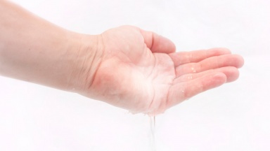 Wasser rinnt aus eine Hand.