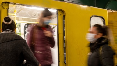 Menschen mit Schutzmasken beim U-Bahn fahren