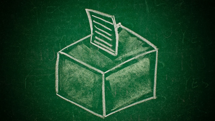 Mit weißer Kreide gemalte Wahlurne auf grünem Tafelhintergrund