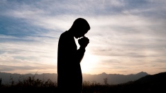 Silhouette eines Mannes im Gebet.