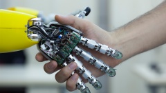 Roboter und Mensch schütteln sich die Hand.