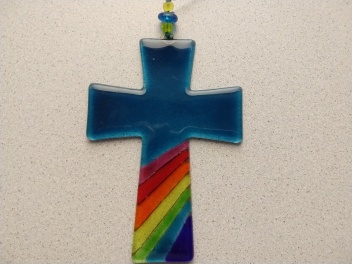 Kreuz mit Regenbogen steht für Leid und Hoffnung.