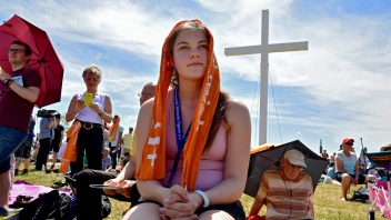 Junge Frau vor Kreuz