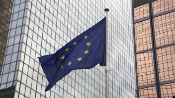 Eine Europaflagge weht vor Glasfassaden in Brüssel.