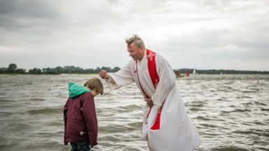 Pastor Wilm aus Hamburg St. Pauli tauft den jungen Wanja.