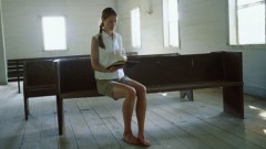 Eine Frau sitzt allein in einer Kirche